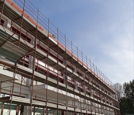 Cantiere edilizio con impalcature su un edificio in costruzione e cielo sereno.